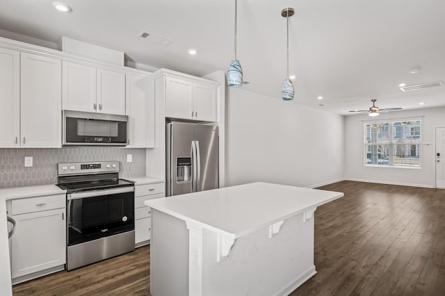 kitchen with stainless steel appliances, light countertops, white cabinets, and decorative backsplash