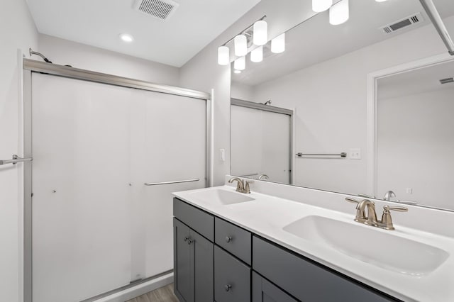 bathroom featuring a stall shower, a sink, and visible vents