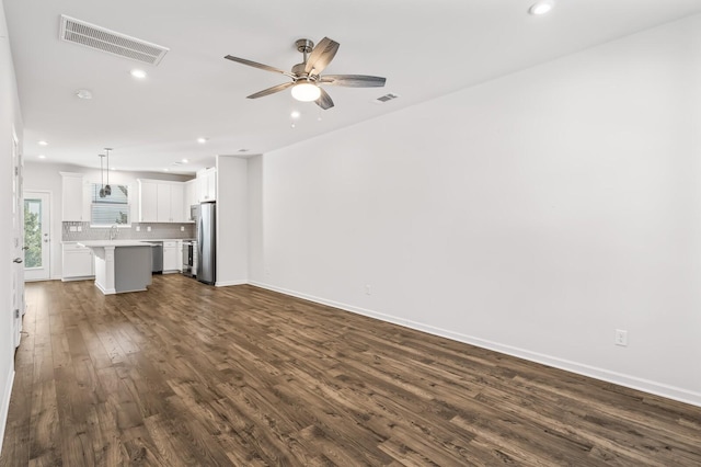 unfurnished living room featuring baseboards, visible vents, a ceiling fan, dark wood-style flooring, and recessed lighting