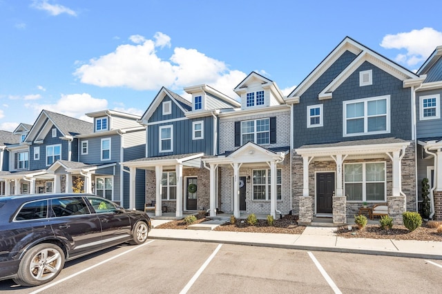 view of property featuring uncovered parking, a residential view, and stone siding