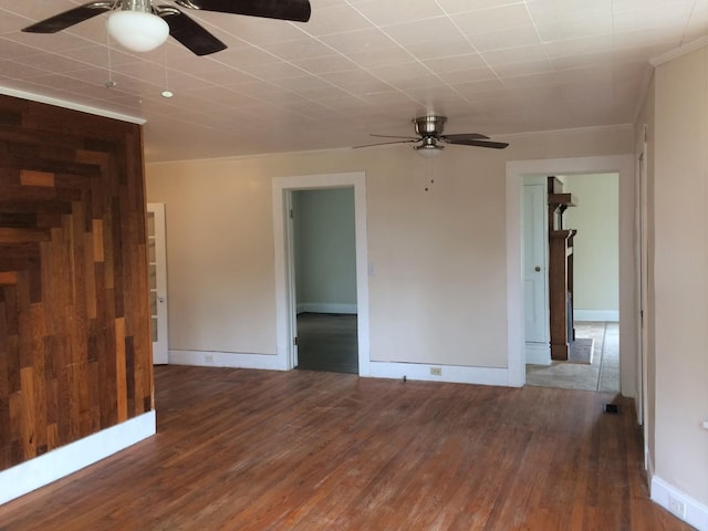 unfurnished room with ceiling fan, ornamental molding, wood finished floors, and baseboards