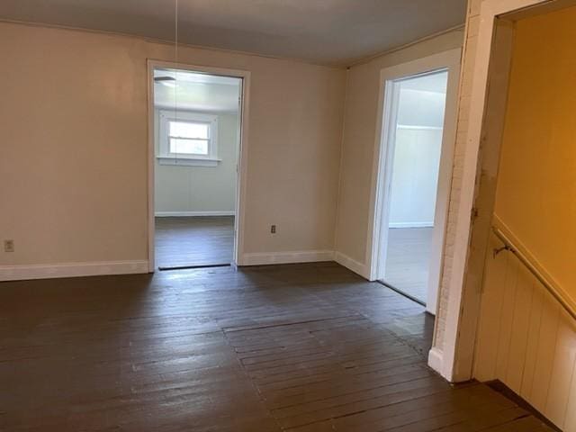 unfurnished dining area with baseboards and dark wood-type flooring