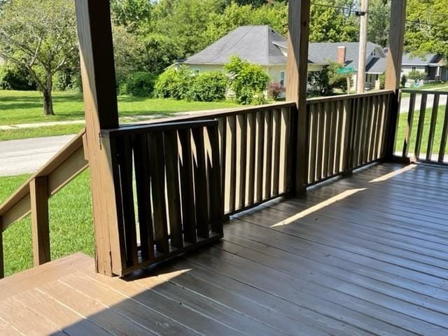 wooden deck featuring a lawn