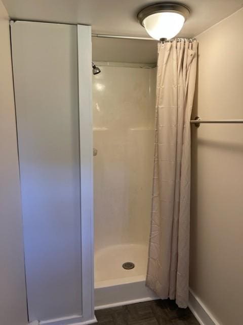 full bath with a stall shower and baseboards