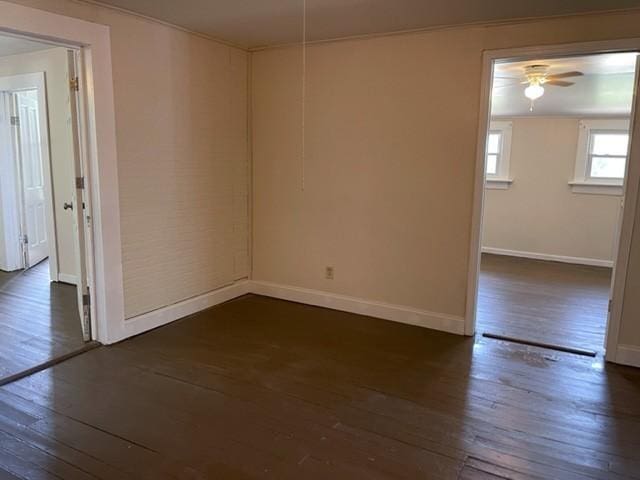 unfurnished room with a ceiling fan, dark wood-style flooring, and baseboards