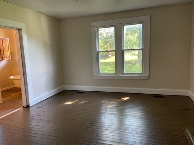 empty room with wood-type flooring and baseboards