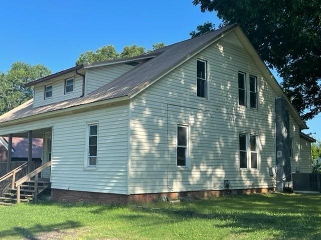 rear view of property featuring a yard