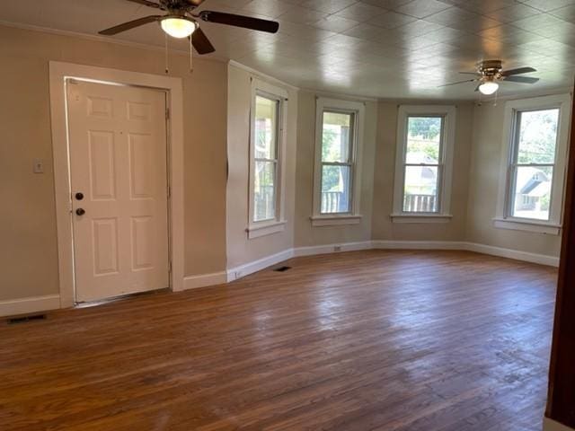 unfurnished room with baseboards, wood finished floors, and ornamental molding