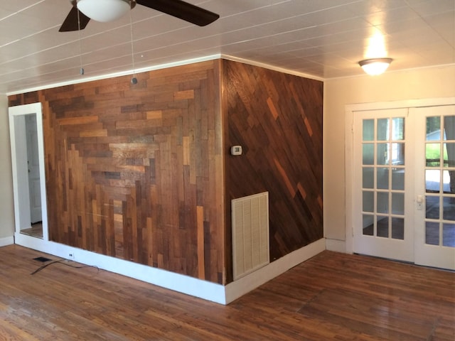 interior space featuring wooden walls, visible vents, ceiling fan, wood finished floors, and french doors