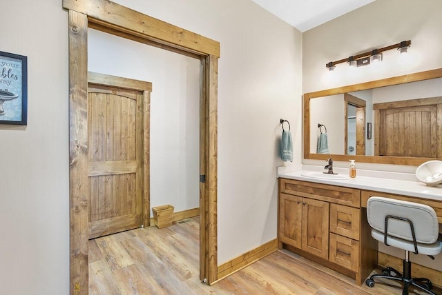 bathroom featuring wood finished floors, vanity, and baseboards