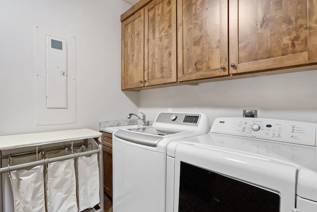 clothes washing area with a sink, washing machine and dryer, cabinet space, and electric panel