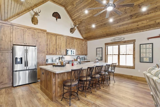 kitchen with light countertops, white microwave, wood ceiling, and stainless steel fridge with ice dispenser