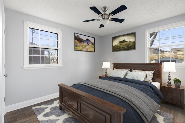 bedroom featuring a ceiling fan, a textured ceiling, baseboards, and dark wood-style flooring