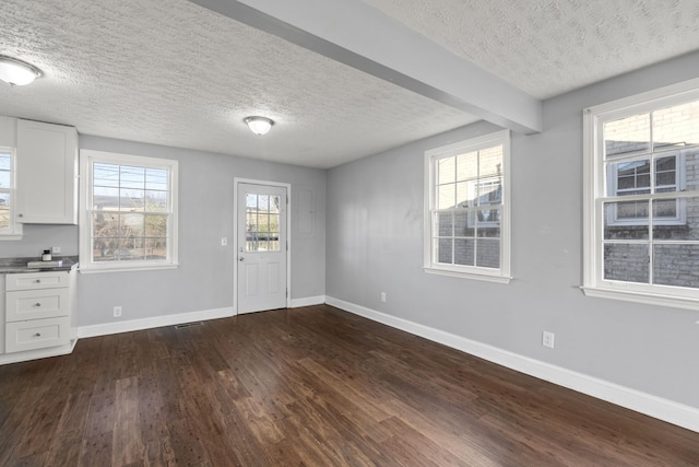 entrance foyer featuring dark wood-style flooring, plenty of natural light, and baseboards