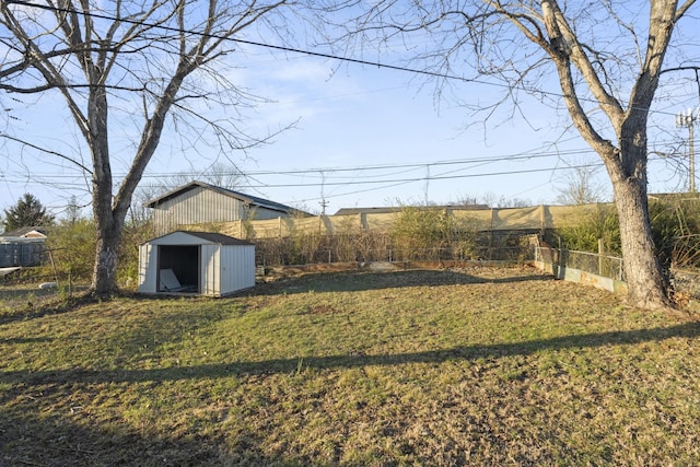 view of yard with an outbuilding, a fenced backyard, and a storage unit