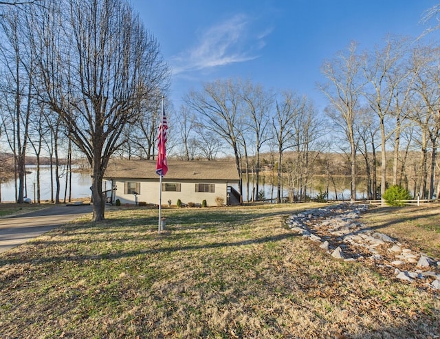 view of front of home featuring a front lawn and a water view