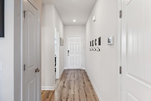 hallway featuring light wood-style floors and baseboards