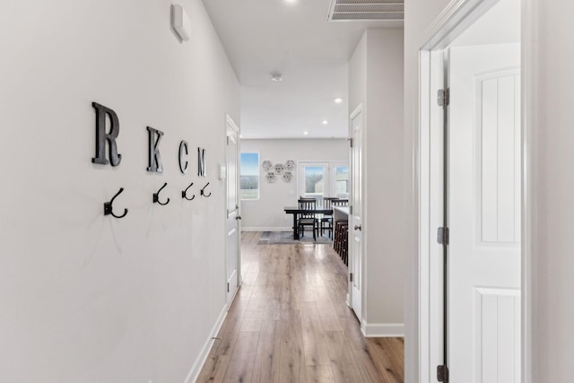 hallway featuring light wood-type flooring, visible vents, baseboards, and recessed lighting