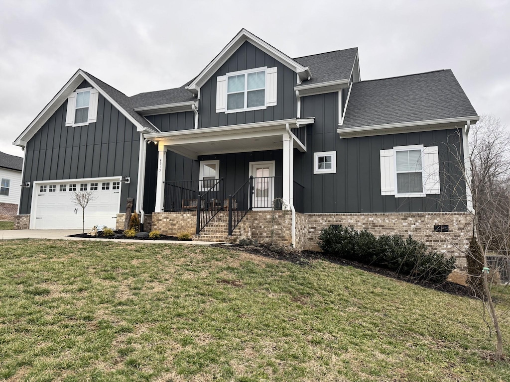 view of front of property with a shingled roof, a porch, board and batten siding, a front yard, and a garage