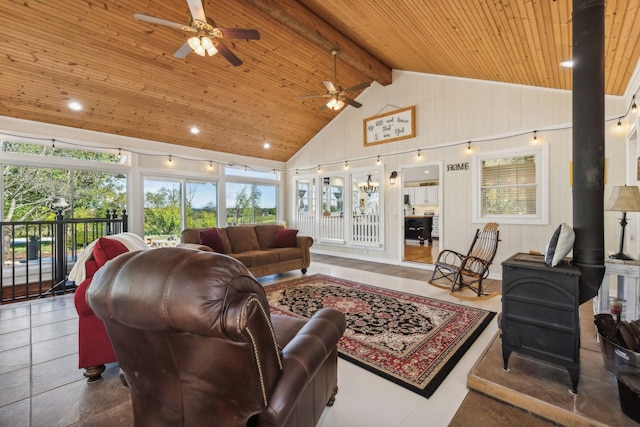 living room featuring a wood stove, beamed ceiling, plenty of natural light, and wood ceiling