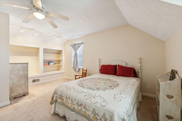 carpeted bedroom with baseboards, visible vents, vaulted ceiling, and a textured ceiling