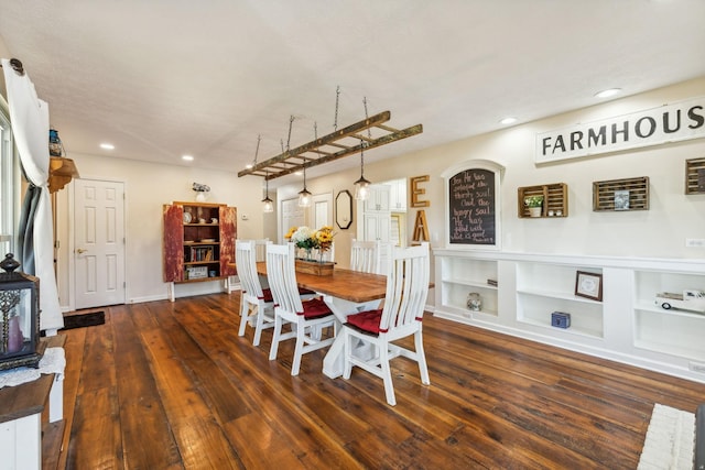 dining room with built in shelves, recessed lighting, and wood finished floors