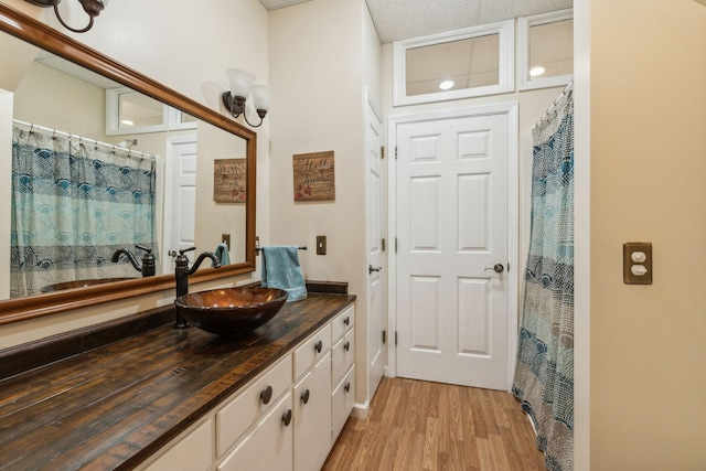 full bathroom featuring curtained shower, wood finished floors, and vanity