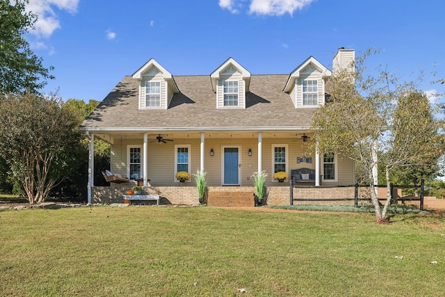 view of front of house with a porch, a chimney, a front lawn, and a ceiling fan