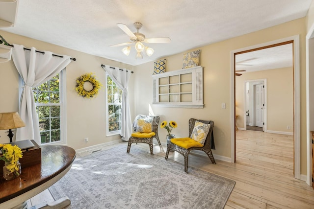 sitting room featuring visible vents, ceiling fan, baseboards, and hardwood / wood-style flooring