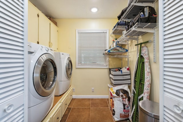 laundry room featuring dark tile patterned flooring, cabinet space, washer and clothes dryer, and baseboards