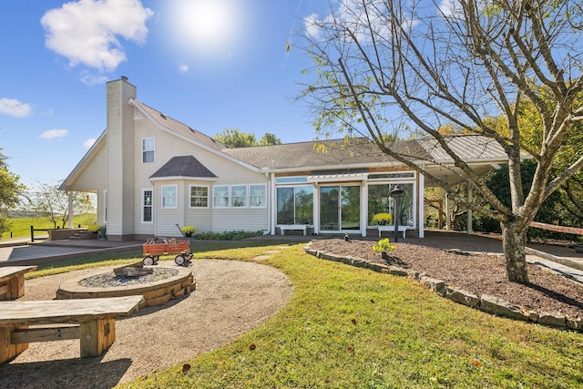 rear view of property featuring a shingled roof, a lawn, and a chimney