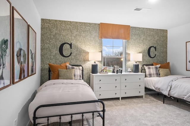 bedroom with light colored carpet, visible vents, and wallpapered walls