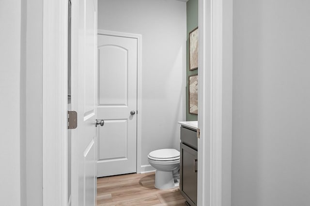 bathroom featuring toilet, wood finished floors, and vanity