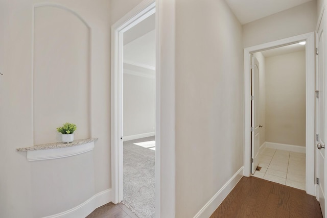 hallway with baseboards and wood finished floors