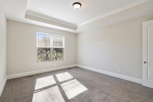 carpeted empty room featuring a raised ceiling, visible vents, crown molding, and baseboards