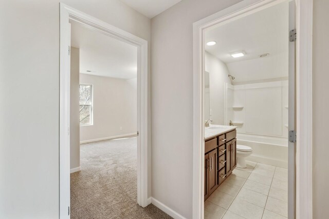 bathroom featuring baseboards, shower / bathing tub combination, tile patterned flooring, and vanity