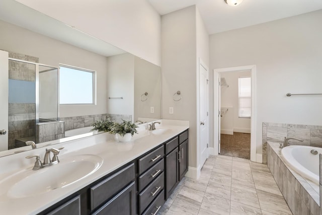 bathroom with a bath, a shower stall, double vanity, and a sink