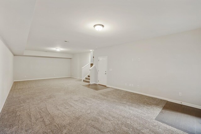 basement with stairs, carpet, and baseboards