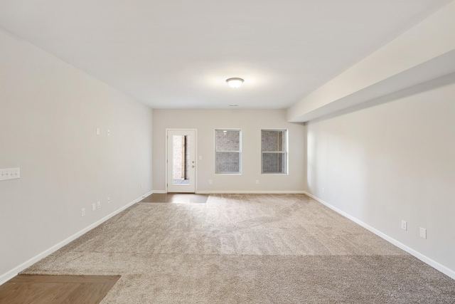 spare room featuring baseboards and carpet flooring