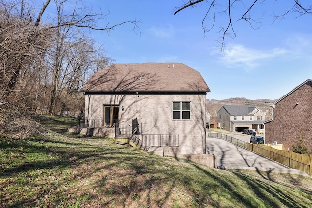 view of property exterior with fence, a lawn, and stucco siding