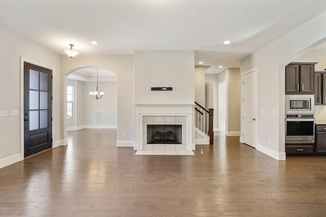 unfurnished living room featuring recessed lighting, visible vents, a tiled fireplace, wood finished floors, and baseboards