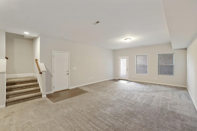 spare room featuring stairway, carpet, visible vents, and baseboards