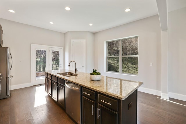 kitchen with baseboards, dark wood-type flooring, stainless steel appliances, a sink, and recessed lighting