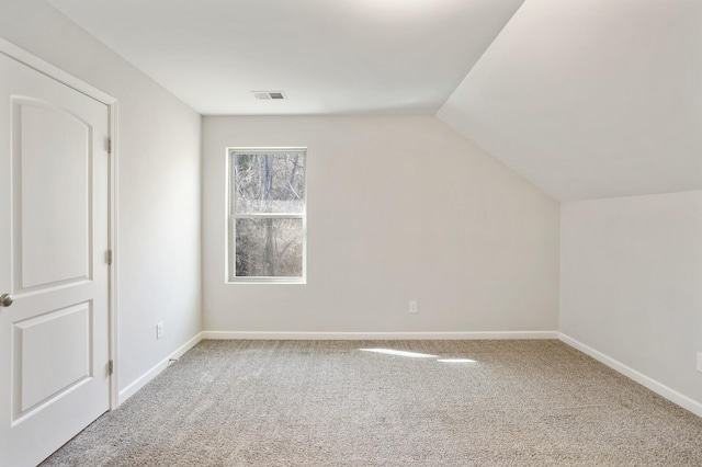 additional living space featuring vaulted ceiling, carpet, visible vents, and baseboards