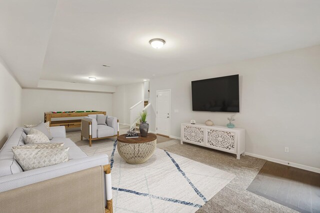 living room featuring carpet floors, stairway, and baseboards