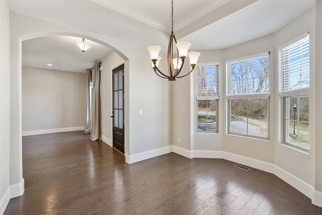 unfurnished dining area with dark wood-style floors, arched walkways, visible vents, and baseboards