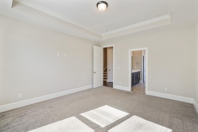 unfurnished bedroom with light carpet, ensuite bath, baseboards, and crown molding