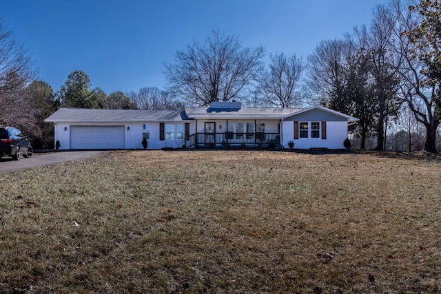 ranch-style home with a garage, aphalt driveway, a porch, and a front yard