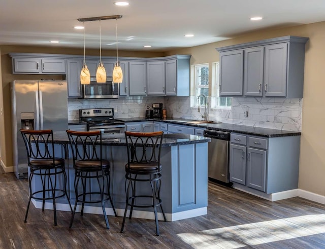 kitchen with appliances with stainless steel finishes, a sink, and gray cabinetry