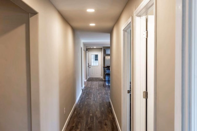 hall featuring dark wood-style floors, recessed lighting, and baseboards